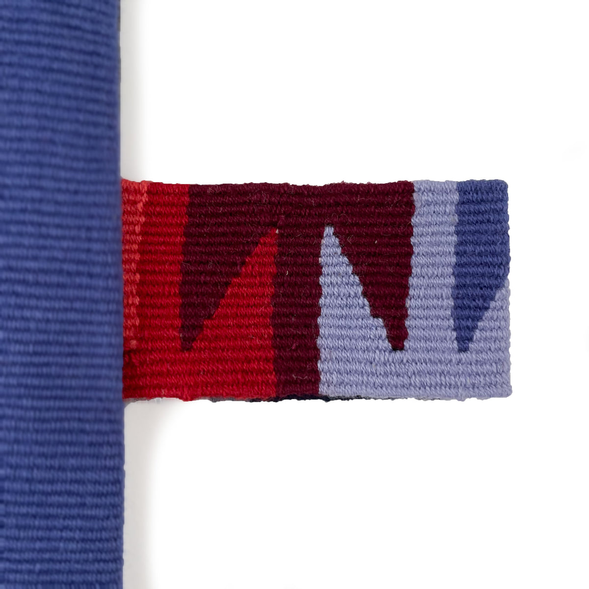 Closeup of handwoven cinta tag in red and blue tones
