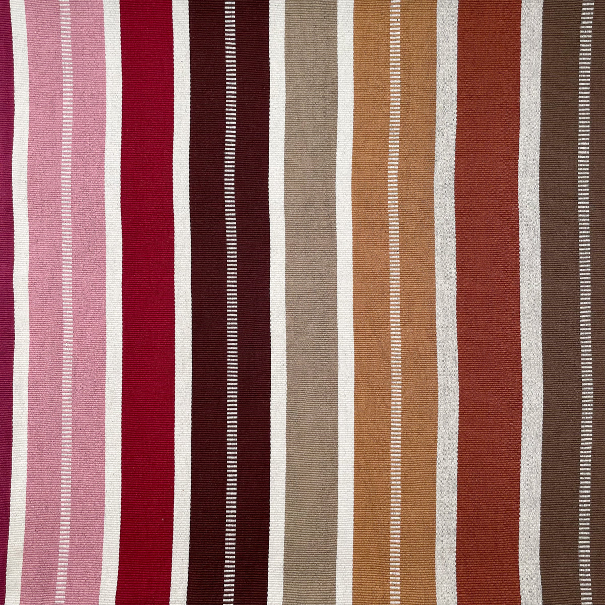 Closeup swatch of cushion cover with colorful stripes grading from pink and red to shades of brown, accented by peine stripe detail
