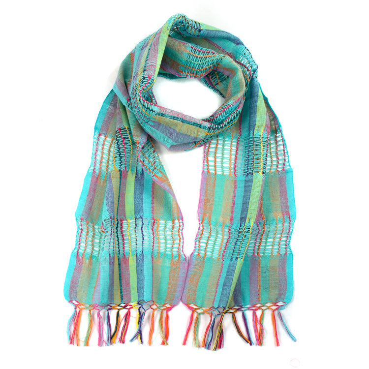 Lattice Weave Scarf in Aqua, made from multicolor cotton threads with aqua overtones, with fringe. The scarf is laid flat, wrapped with a circle on white background.