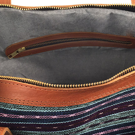 Close-up of the interior side of the Weekender Travel Bag, showing leather trim on the bag&#39;s zipper closure, as well as the leather-trim zipper pocket inside the bag.