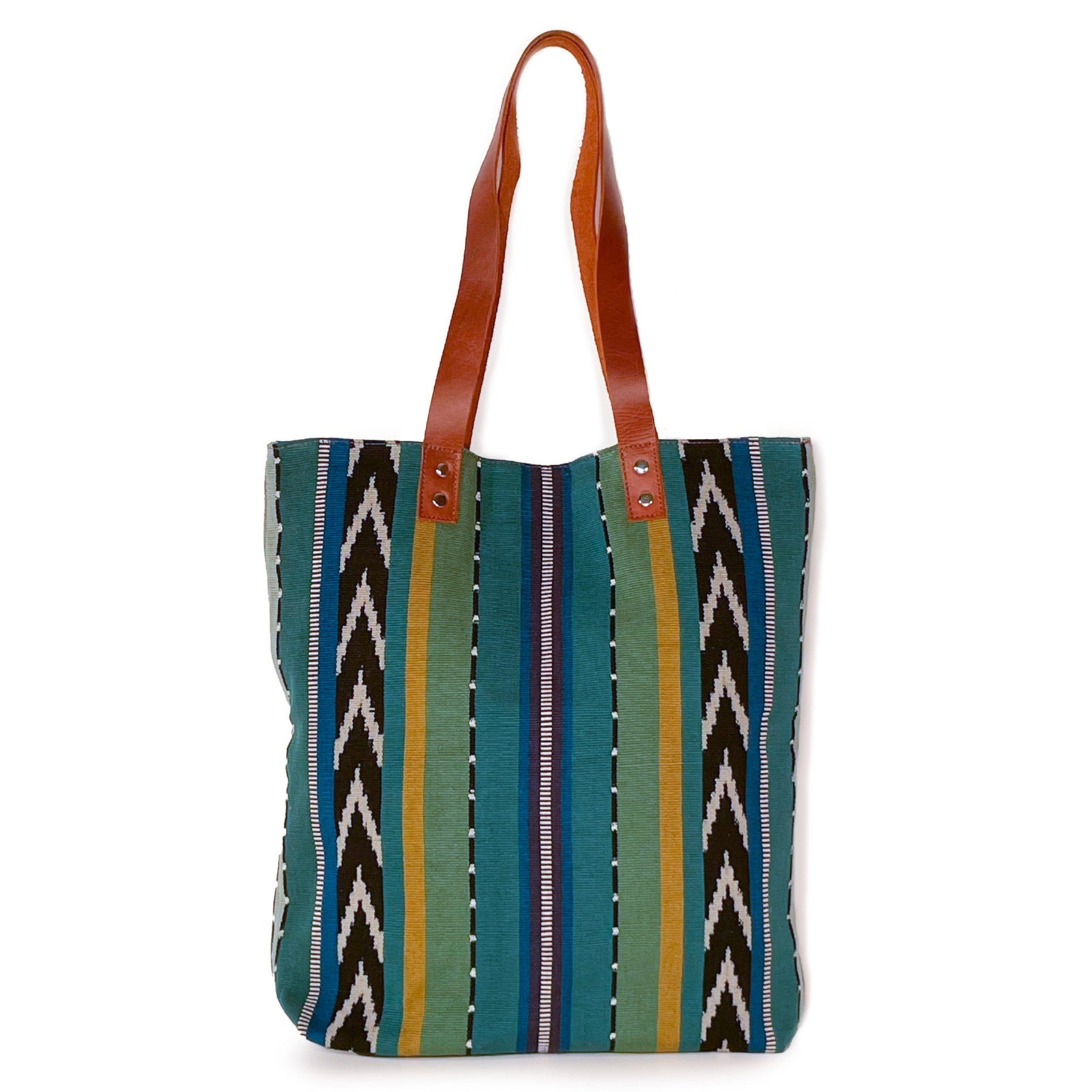 Front view of Matea Bag in Green Jaspe, featuring traditional jaspe and peine stripes in black and white, chevron jaspe in black and sage green, between stripes in different shades of green.  With brown leather strap handle.