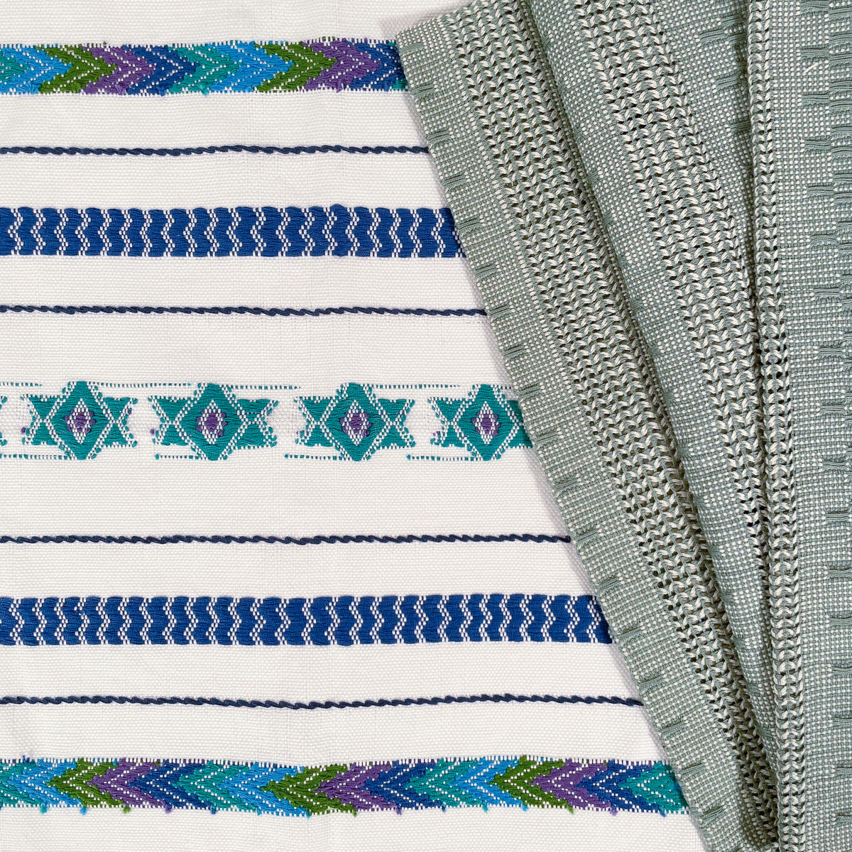 Close up view of brocade detail on Brocade Challah Cover in Blue & Teal, with coordinating Calado Table Runner in Sage