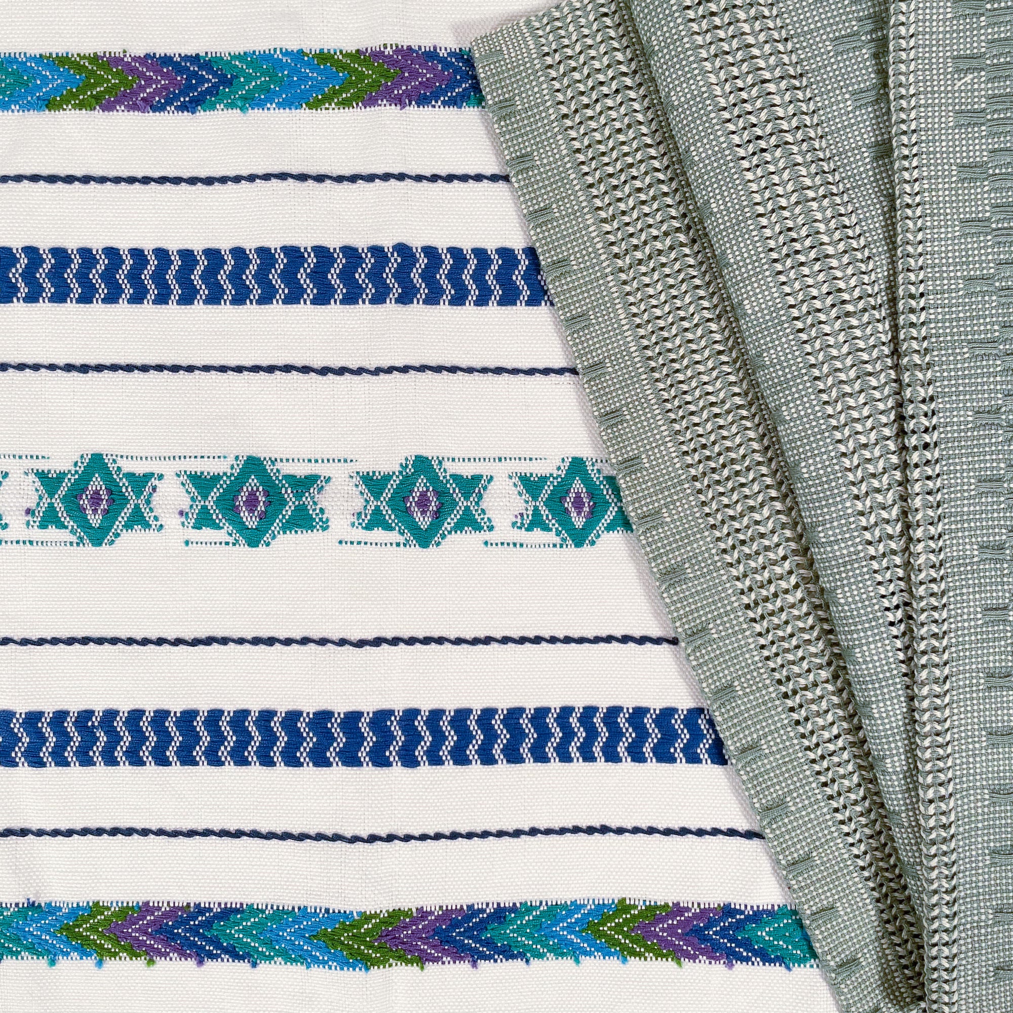 Overhead view of Brocade Challah Cover in Blue & Teal, featuring teal brocade details on a white background, with fringed edges