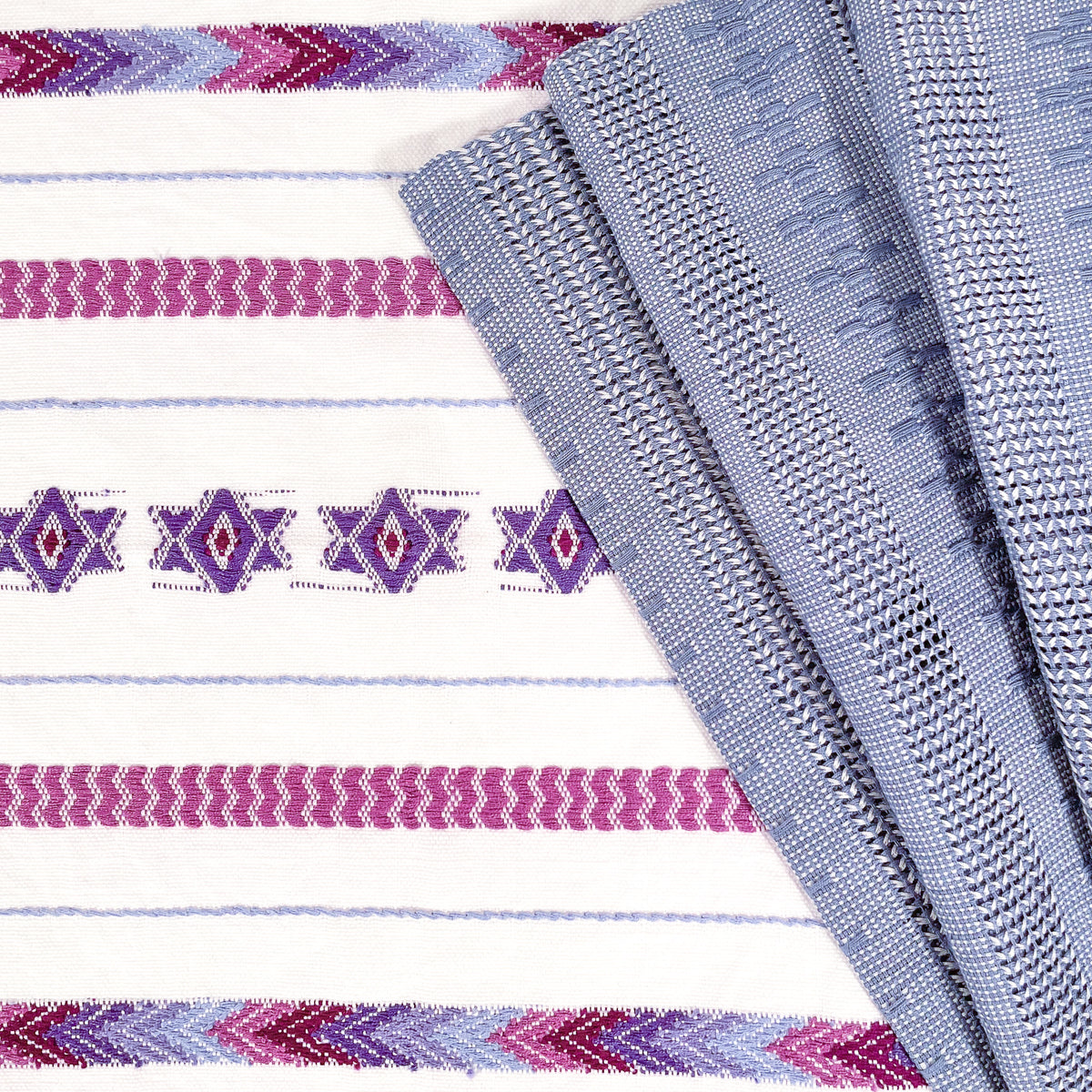 Closeup view of Brocade Challah Cover in Purple, seen with coordinating Calado Table Runner in Blue