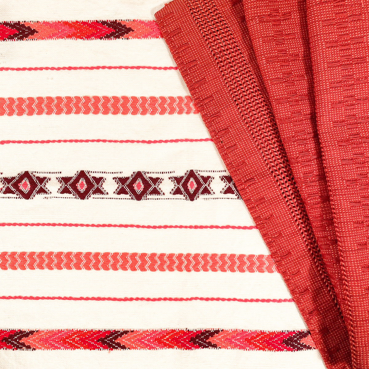 Close up view of Brocade Challah Cover in Red, showing brocade details, with Calado Table Runner in Terracotta