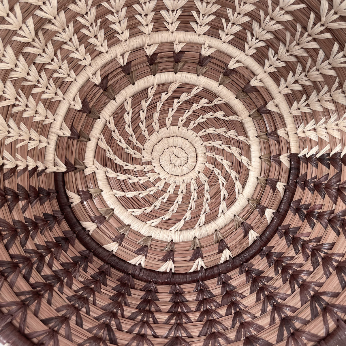 Closeup view of Cafe Basket, showing detail of design with with half of raffia stitching in natural, and half of raffia stitching dyed brown
