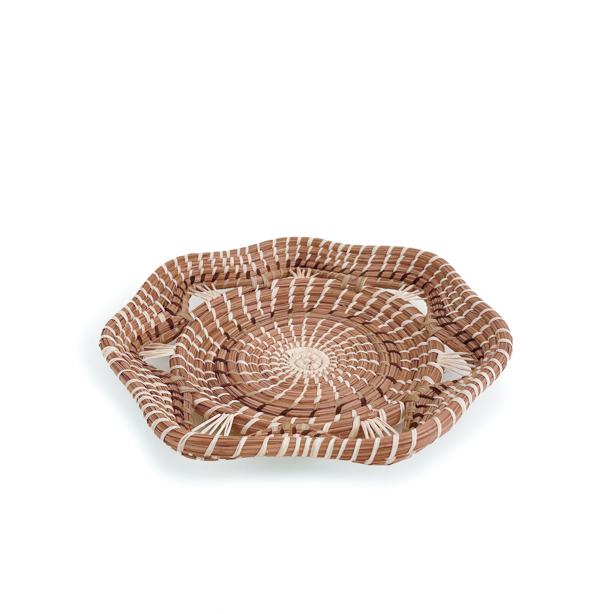 Angled view of woven pine needle Adela Basket, with geometric rim, on white background