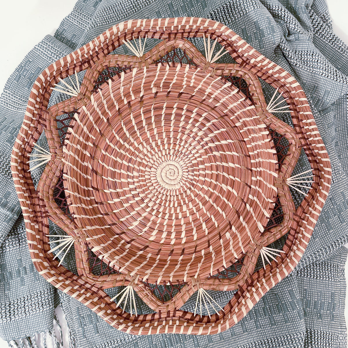Pine needle Andrea Basket with geometric rim and mesh details on sage green textile background