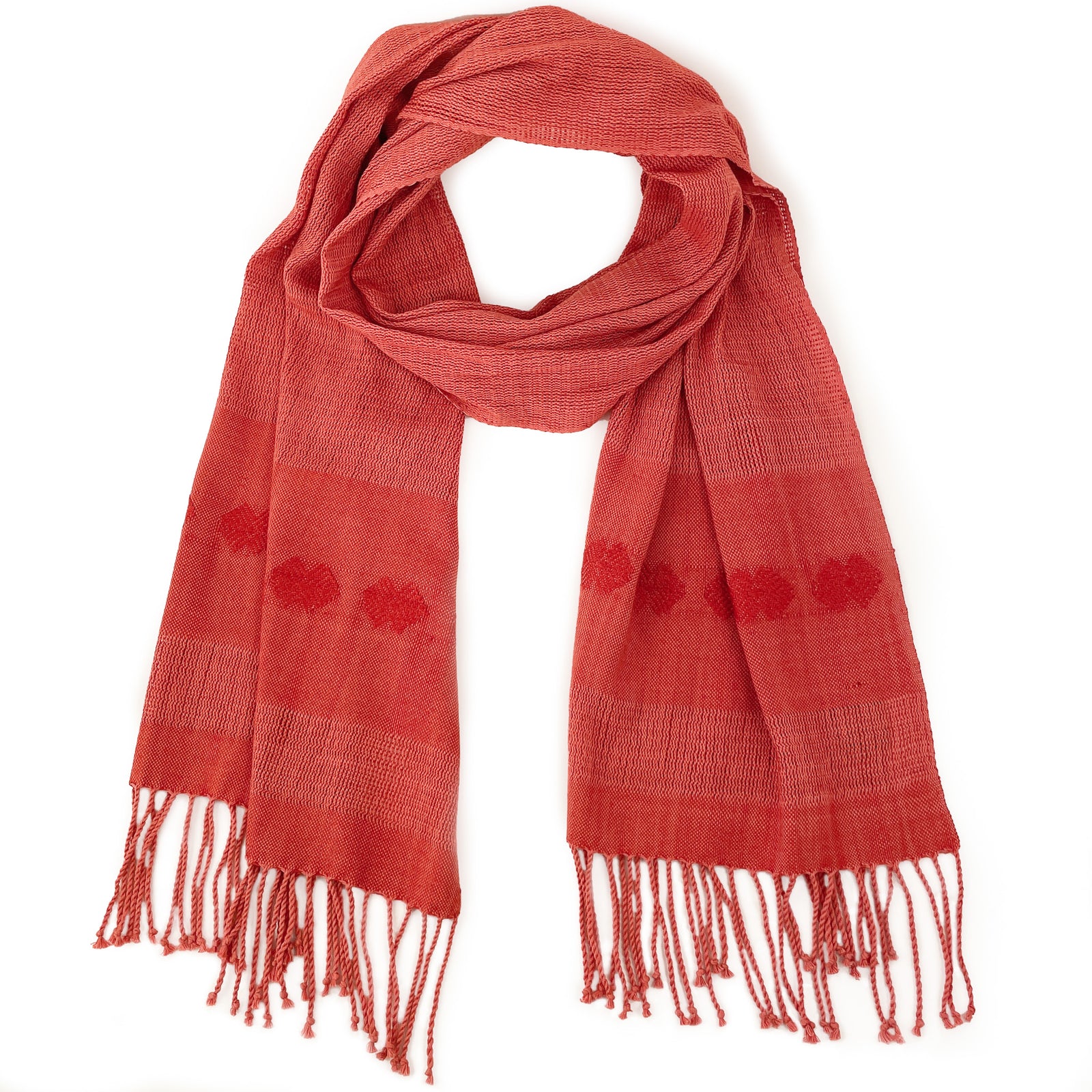 Flatlay photo of coral colored shawl with hand knotted fringe and brocade detail