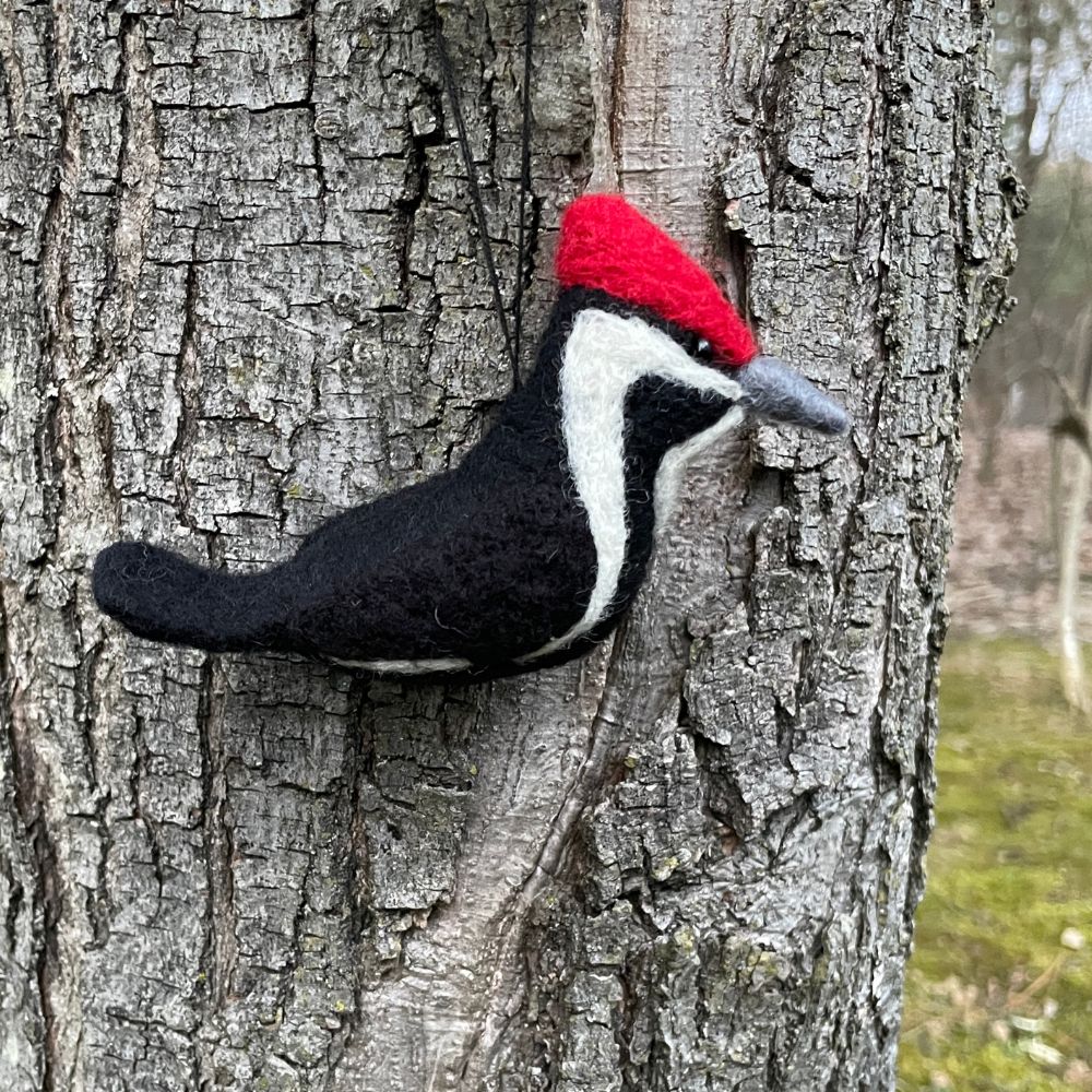 Felted woodpecker against a tree trunk