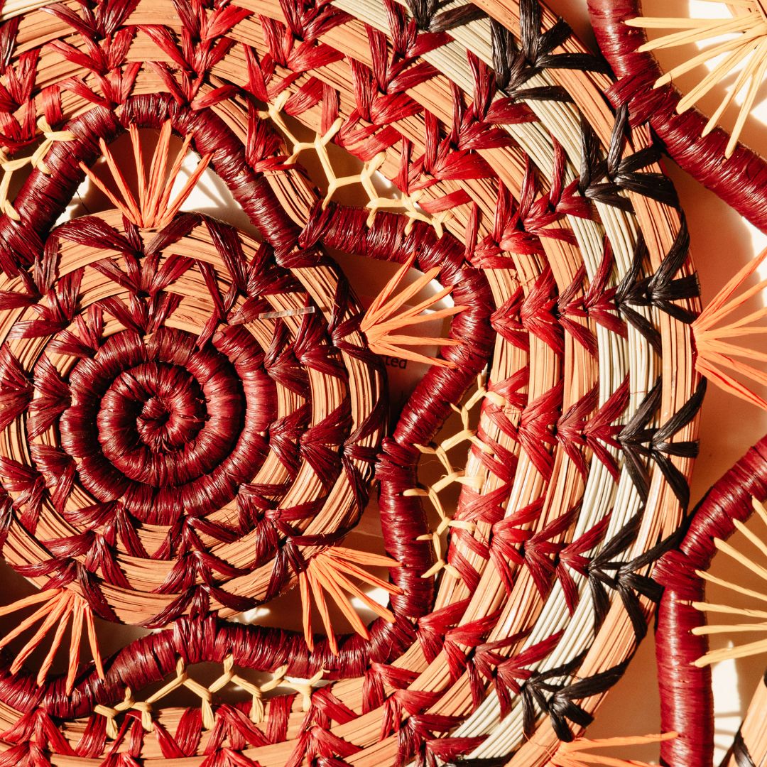 Closeup of center of Rosenda in Wine Basket, showing pine needle coils, raffia stitching, and star-shaped center.