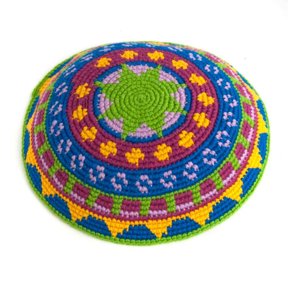 Crochet kippah with bright green star in center with colorful, patterned border