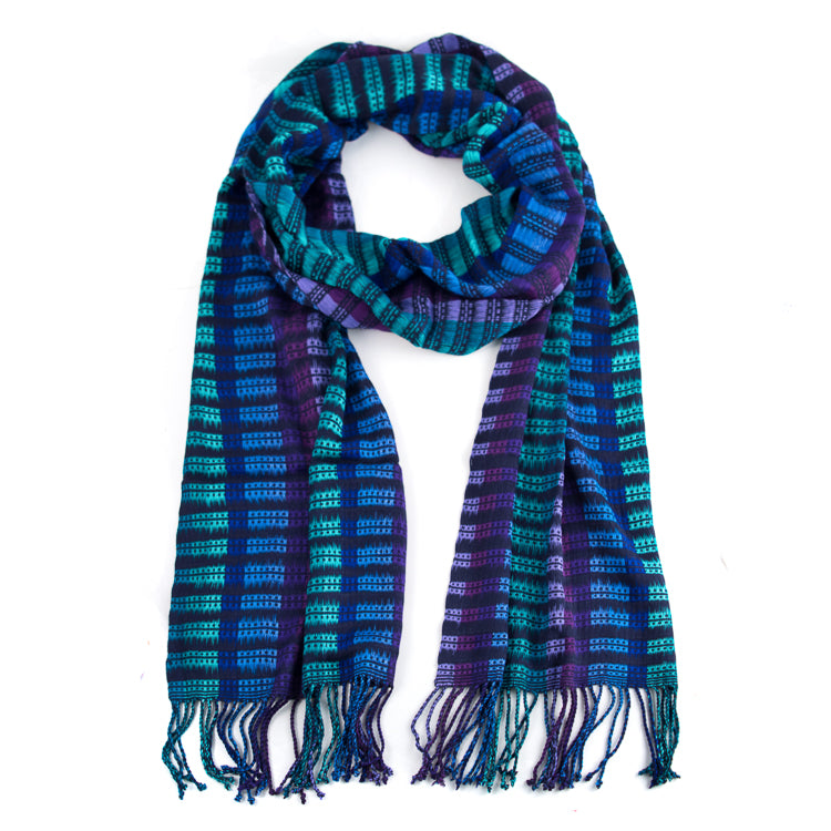 Abelina scarf in Blues & Teal, made from rayon threads in blue tones. The scarf is laid flat, wrapped with a circle on white background.