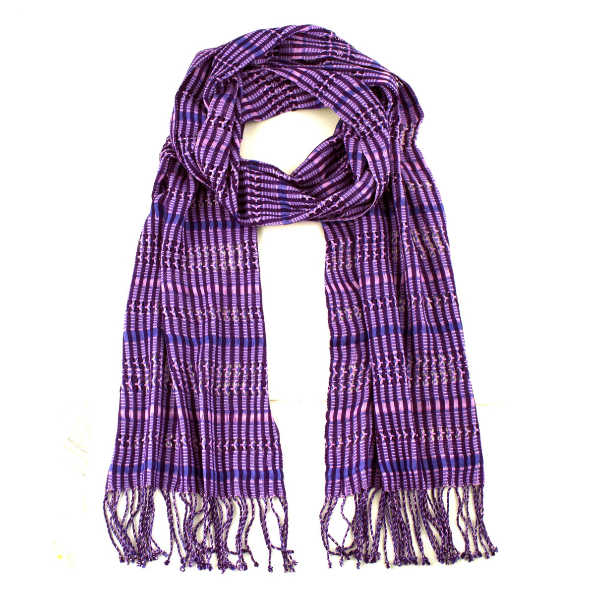 Linda Scarf in Violet, woven from rayon threads in purple and navy tones, with twisted fringe. The scarf is laid flat, wrapped with a circle on white background.