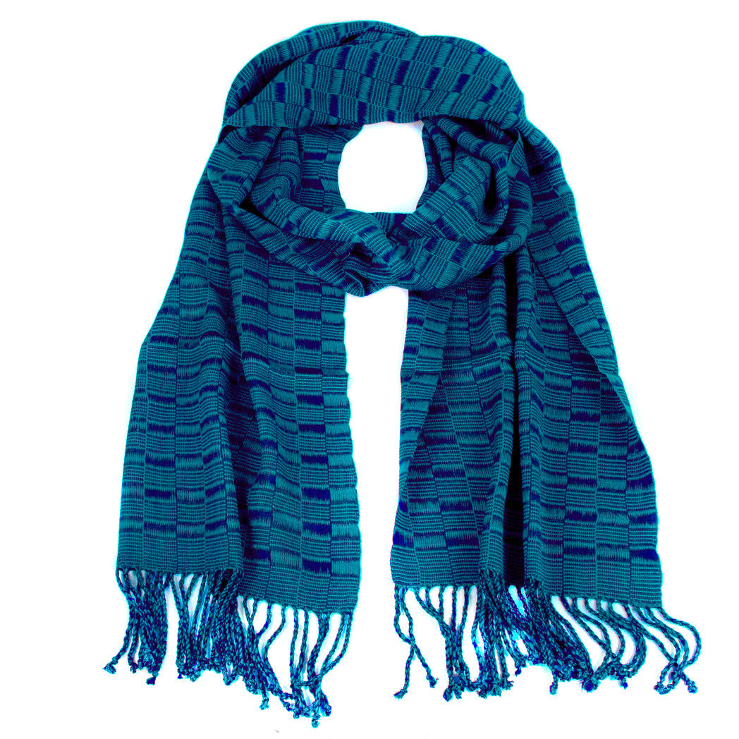 Elsa Scarf in Teal & Navy, made from rayon threads in blue and teal tones, with twisted fringe. The scarf is laid flat, wrapped with a circle on white background..