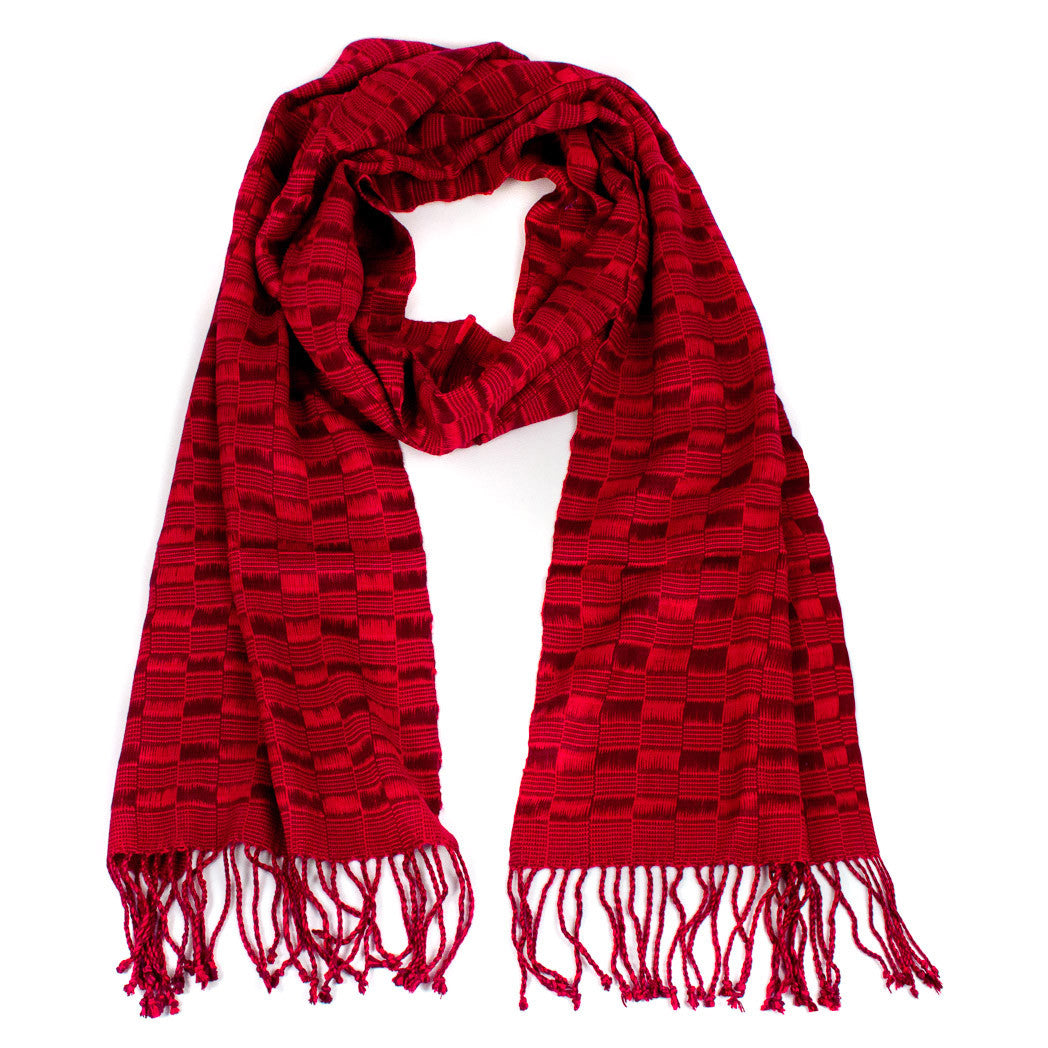 Elsa Scarf in Reds, made from rayon, with twisted fringe. The scarf is laid flat, wrapped with a circle on white background..