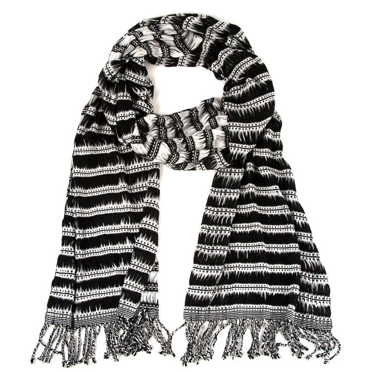 Maya Moonlight Scarf, woven from rayon threads in black and white stripes and patterns, with twisted fringe. The scarf is laid flat, wrapped with a circle on white background.