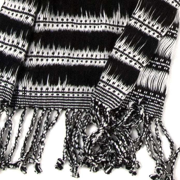 Closeup of Maya Moonlight Scarf, showing detail of black and white stripes and pattern, with twisted fringe