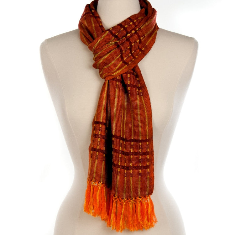 Lucia Scarf in Orange draped on mannequin, woven from rayon threads in orange and yellow tones, with fringe