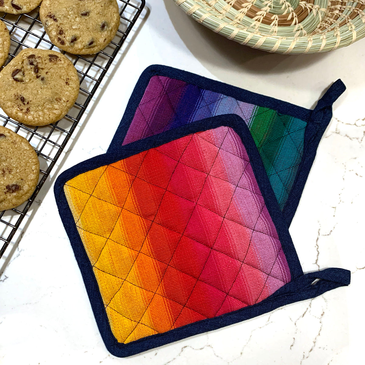 handwoven rainbow potholders with cookies and basket